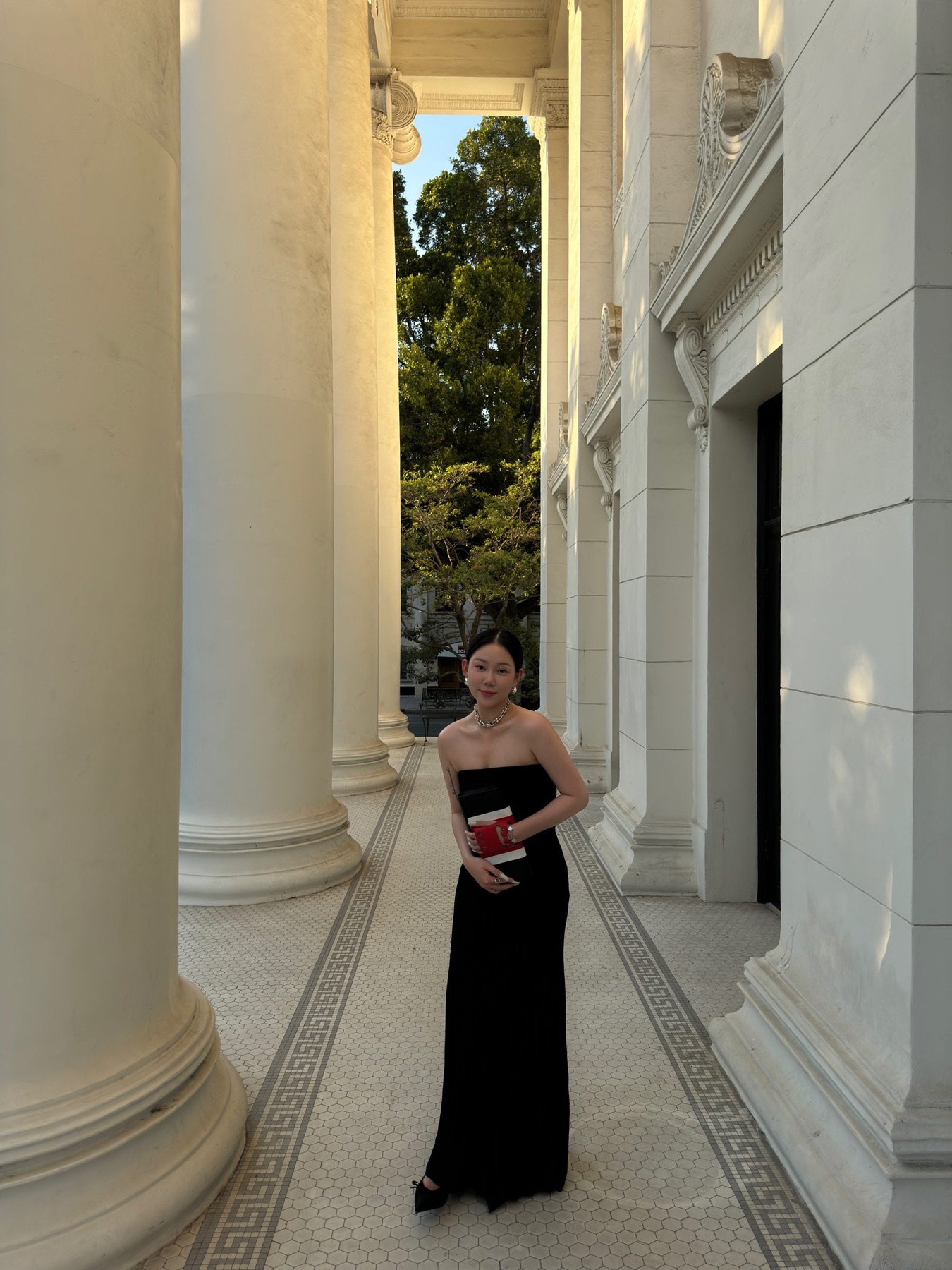 Black gown in a narrow stairwell with architectural lines