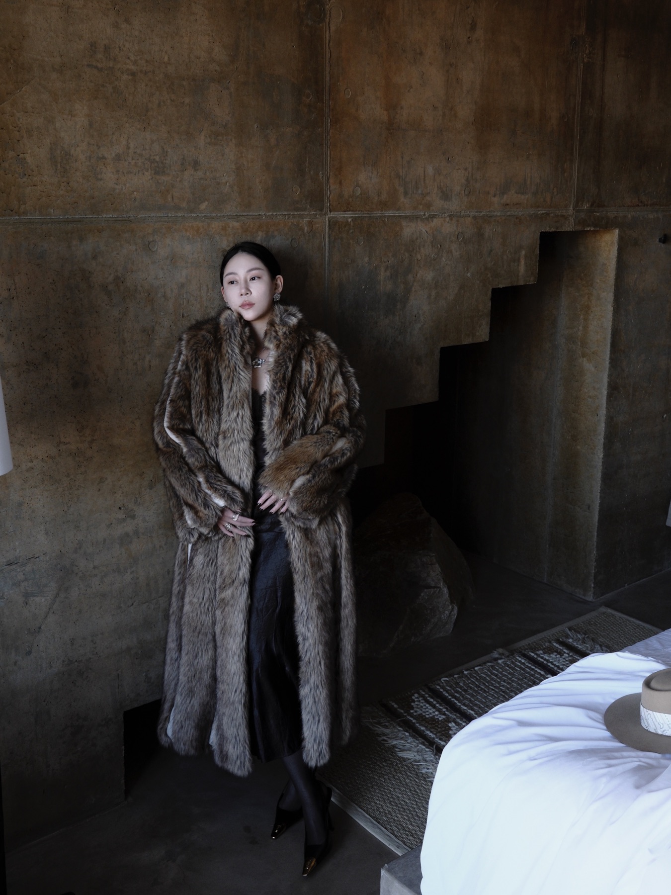 Fur coat styling inside a concrete interior