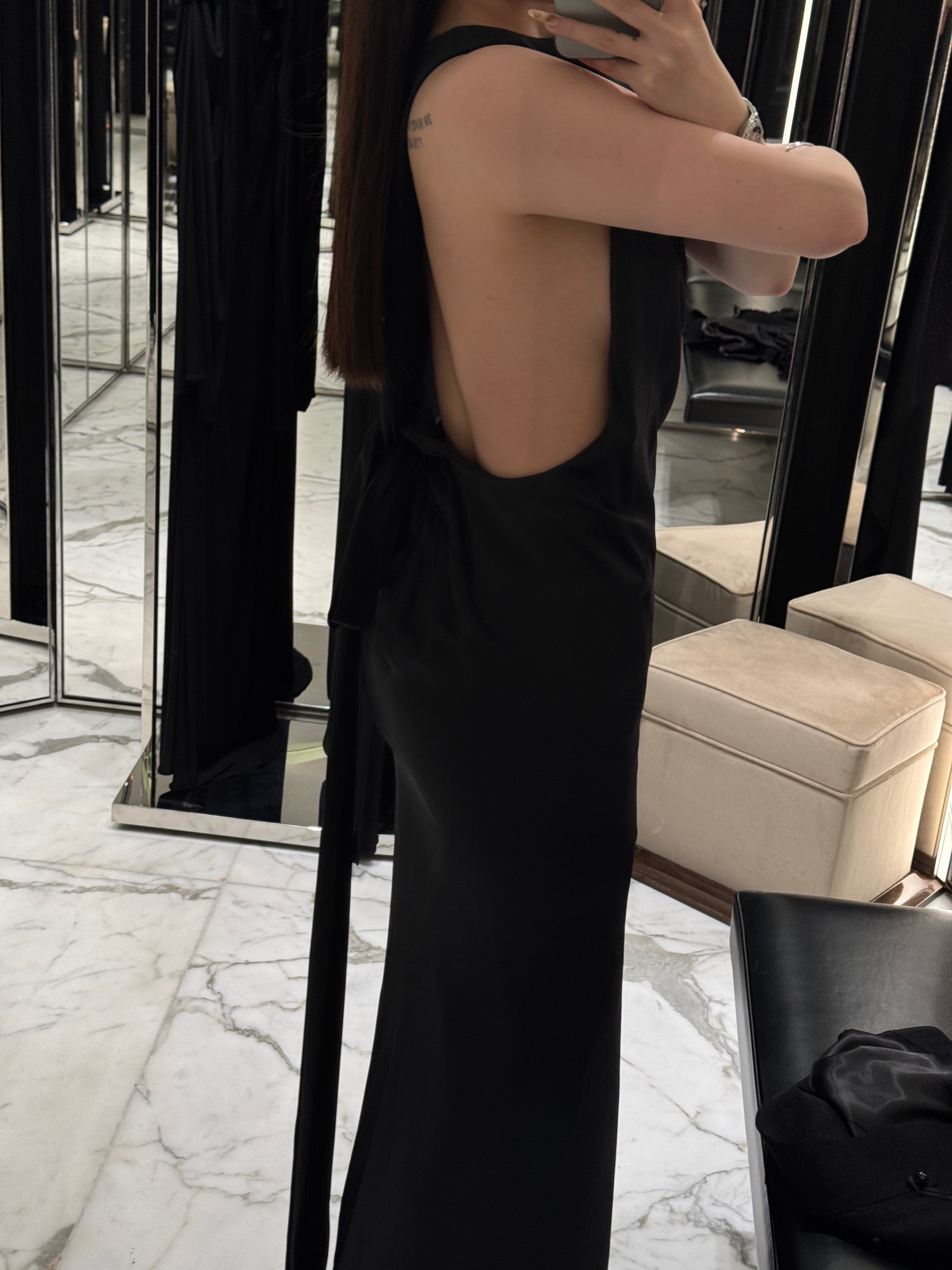 Black dress fitting detail in a mirrored styling room
