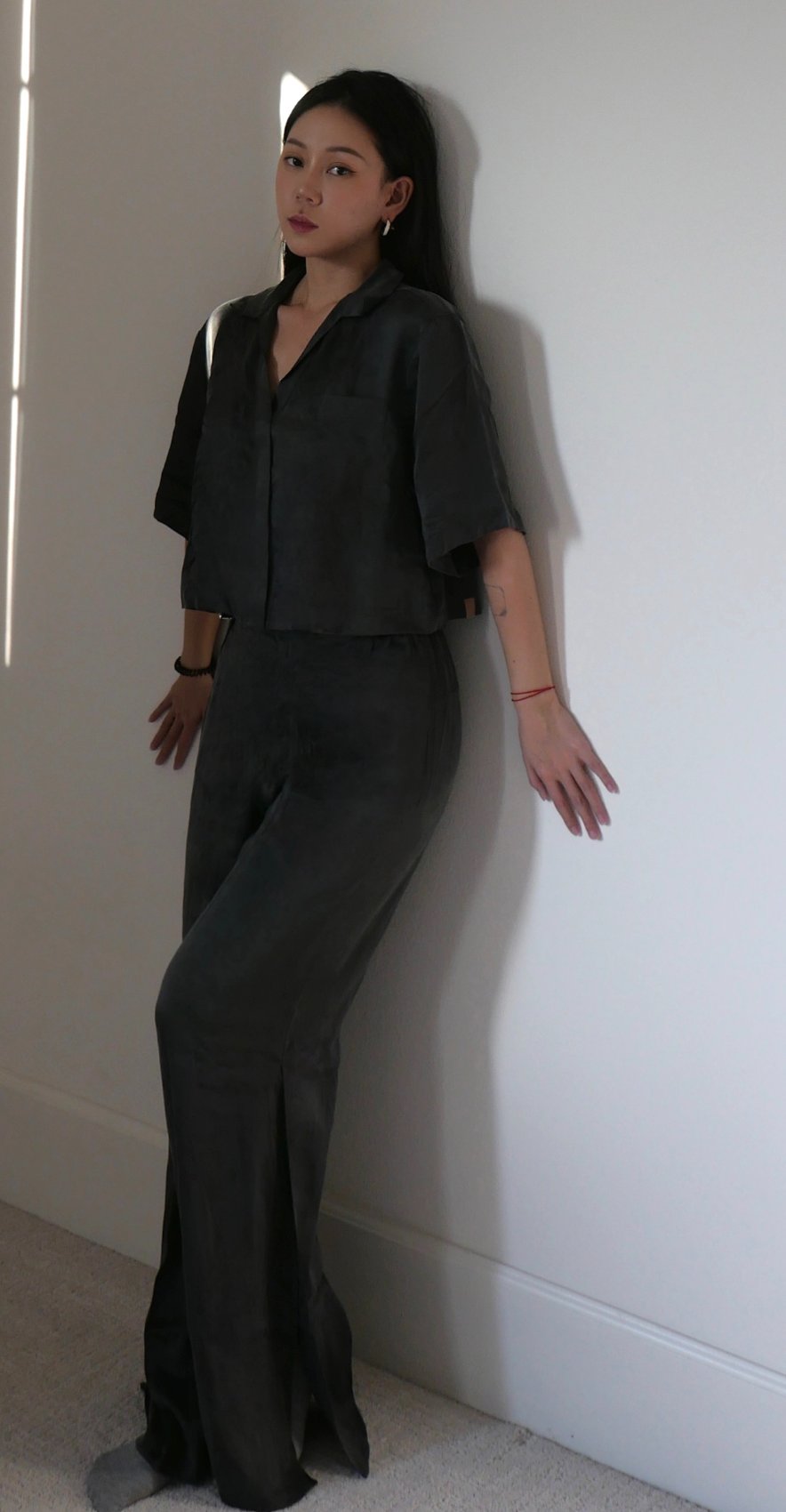 Lunya charcoal silk set in a full-length lean into a bright corner