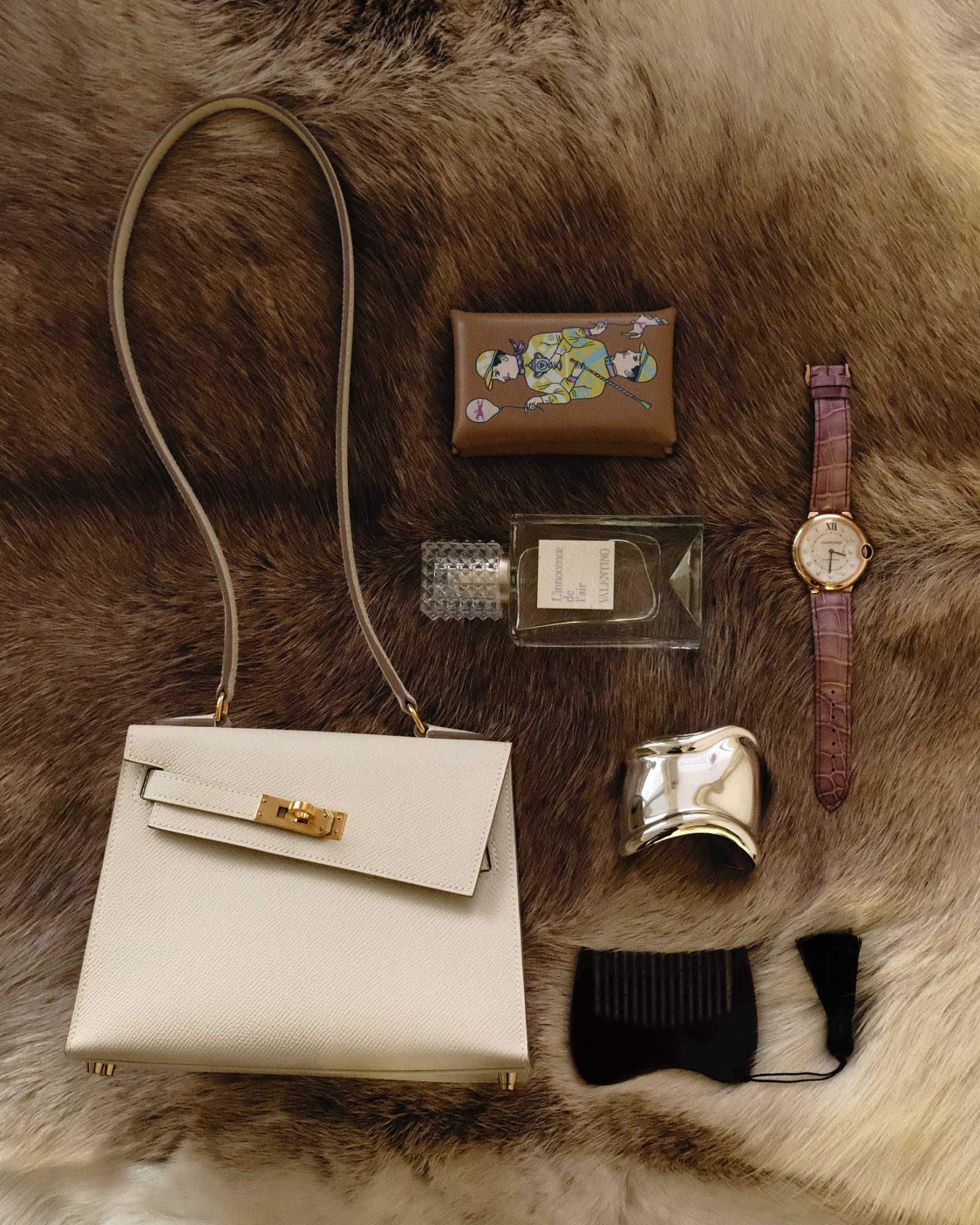Valentino L'innocence de l'air fragrance with a white top-handle bag and Cartier watch on fur
