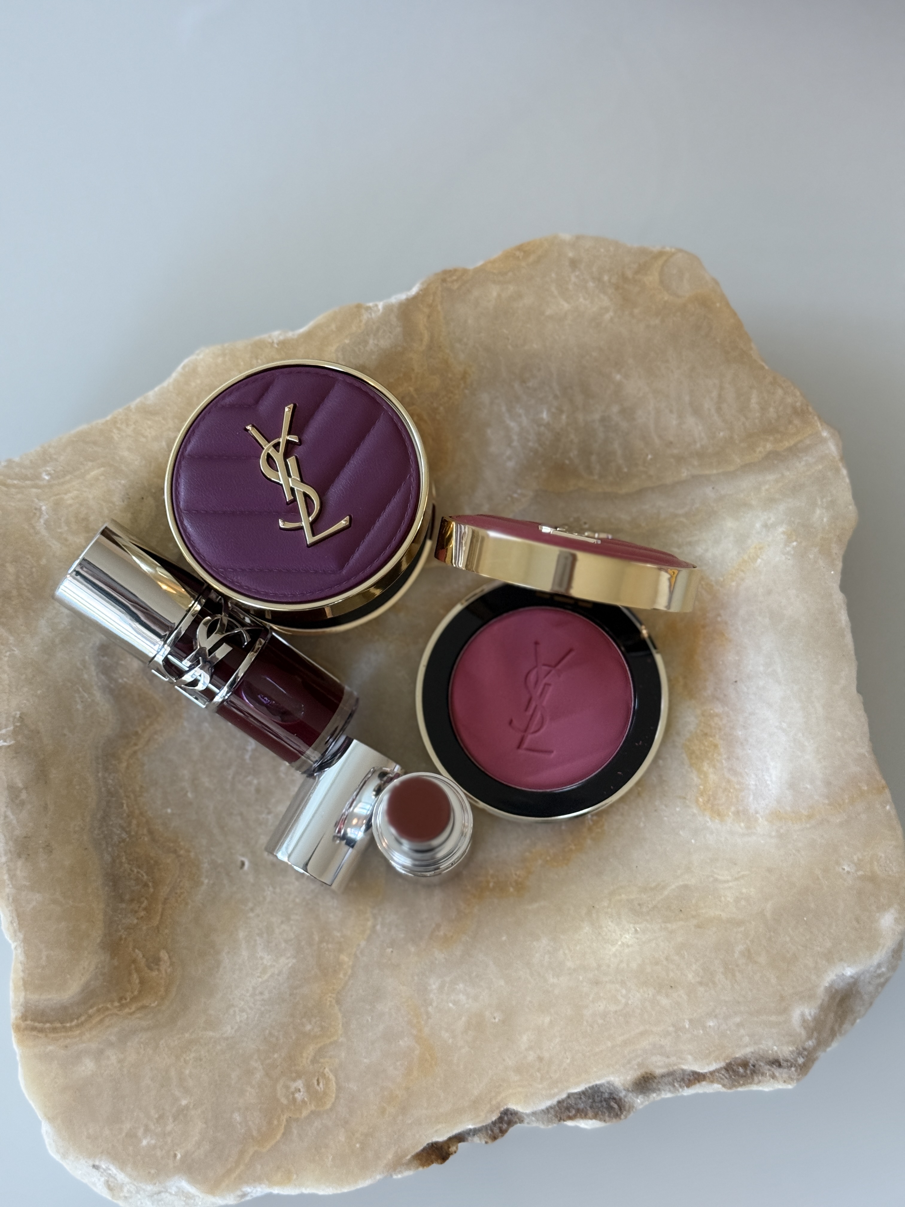YSL Beauty products arranged on stone