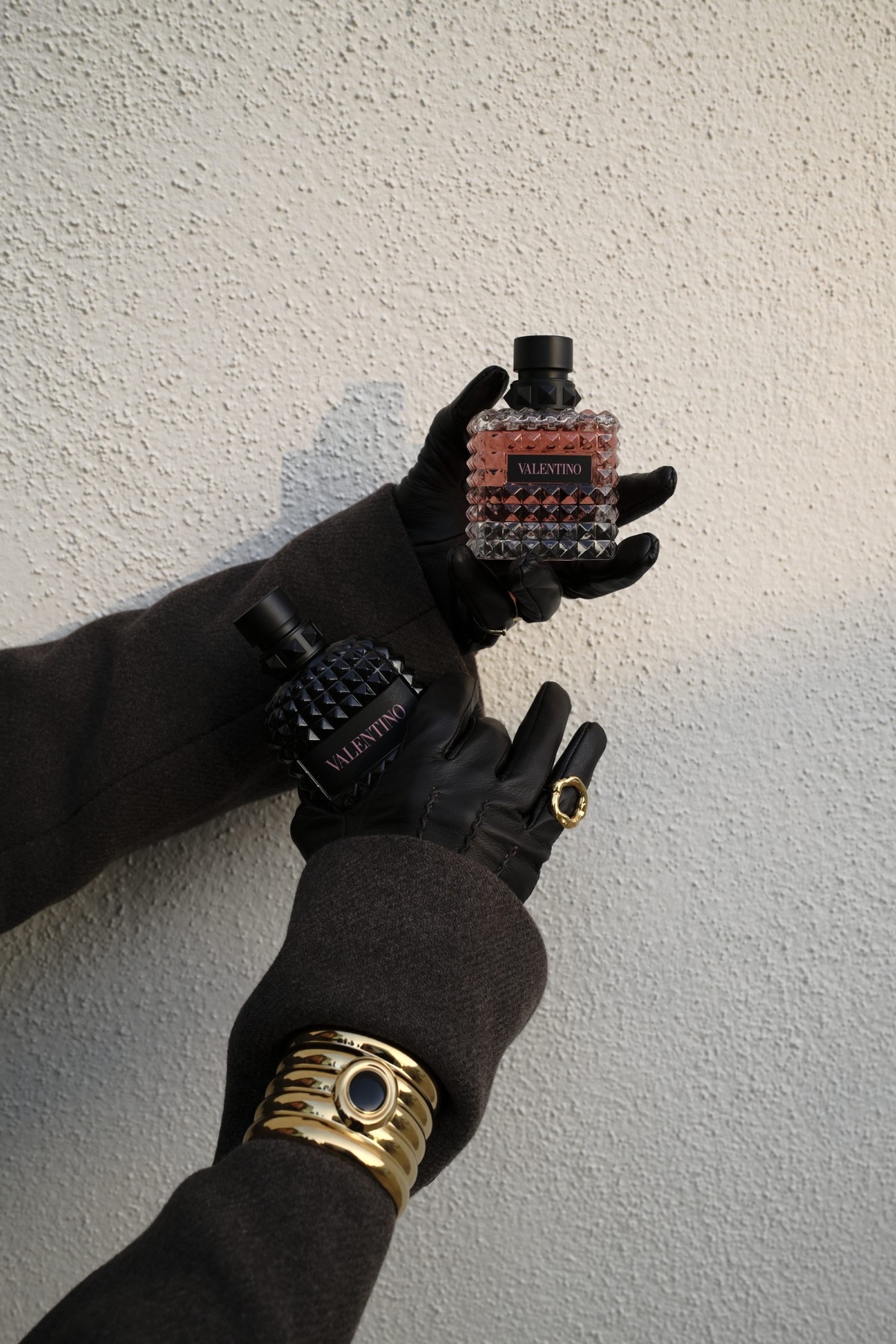 Valentino fragrance held in black leather gloves